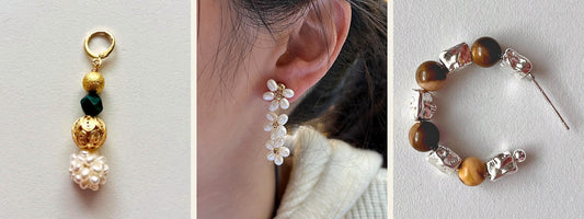 Three single earrings: a gold drop with a green stone and pearl cluster, a pearl flower vine drop worn in one ear, and a silver hoop with tiger eye beads