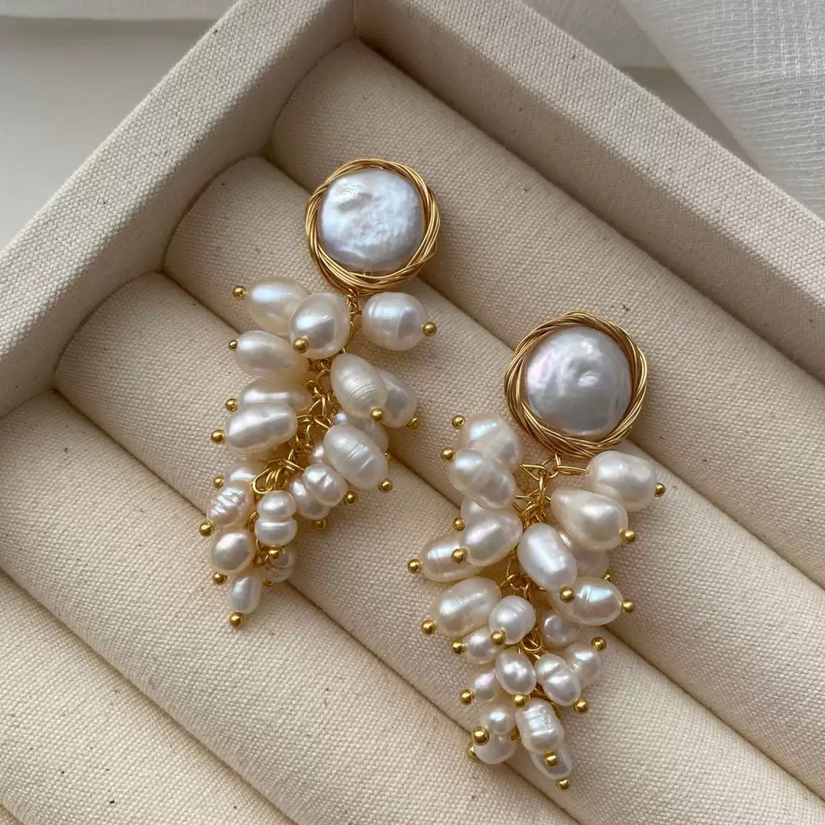 Freshwater pearl cluster drop earrings displayed on a jewellery roll